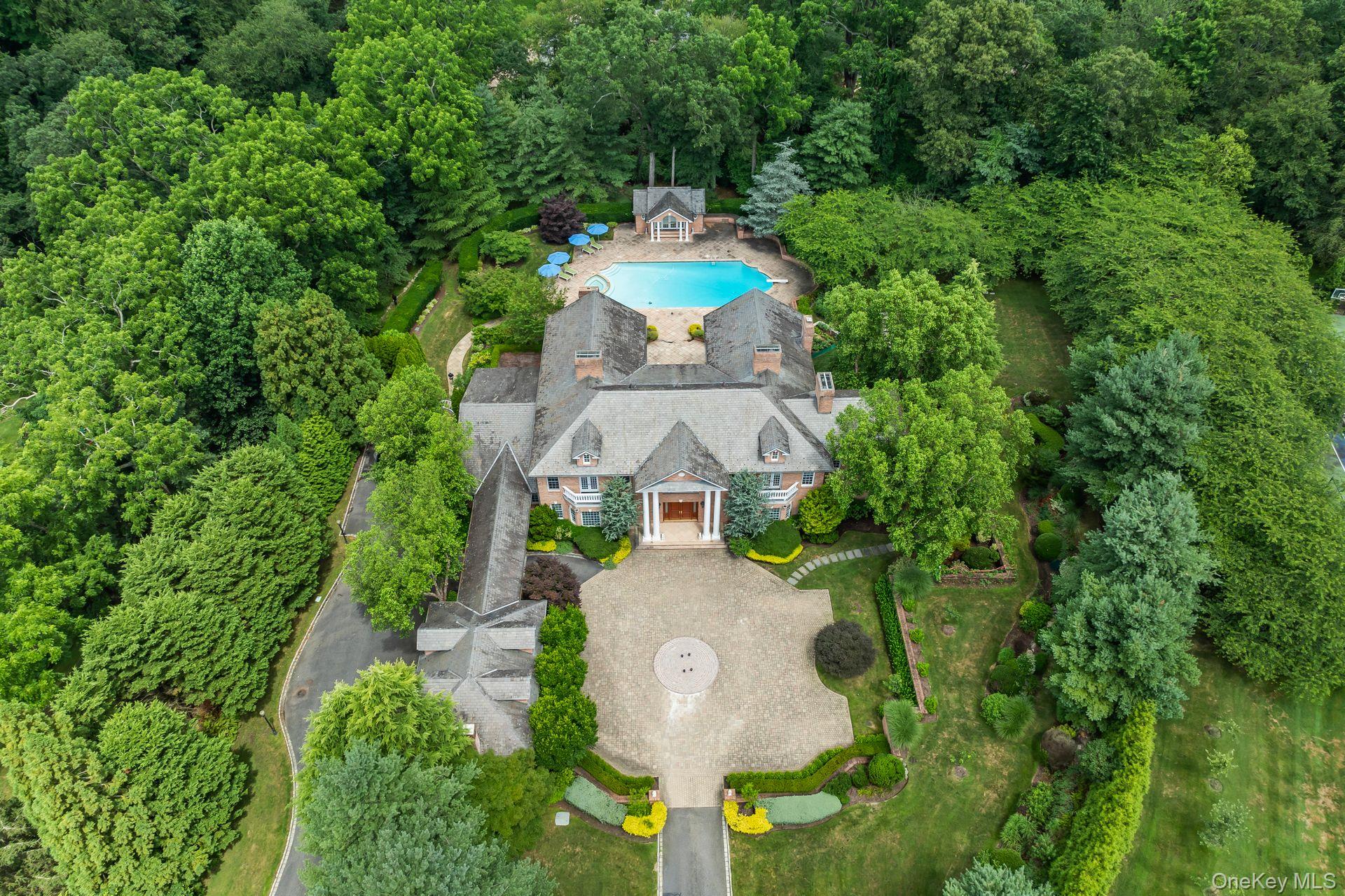 Aerial view of property and surrounding area featuring a forest and a pool area