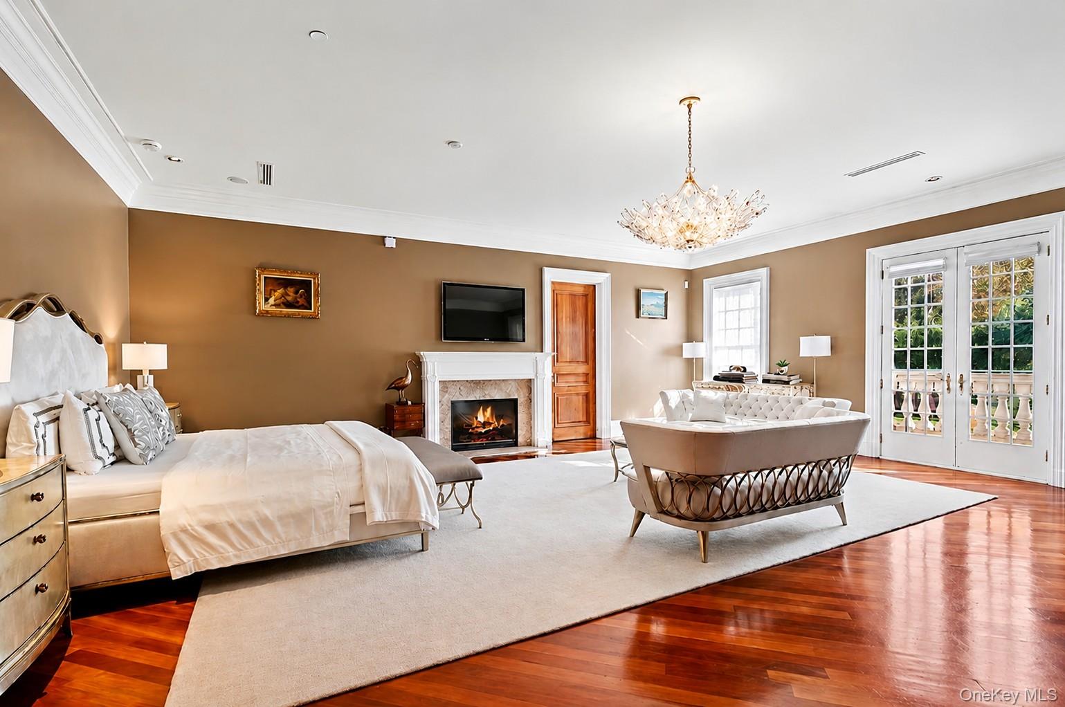 660 Chicken Valley Road Locust Valley, NY 11560 - Photo 19 of 48 Spacious room featuring rich wood-finish flooring, a white stone fireplace with an integrated mantel, and white French doors