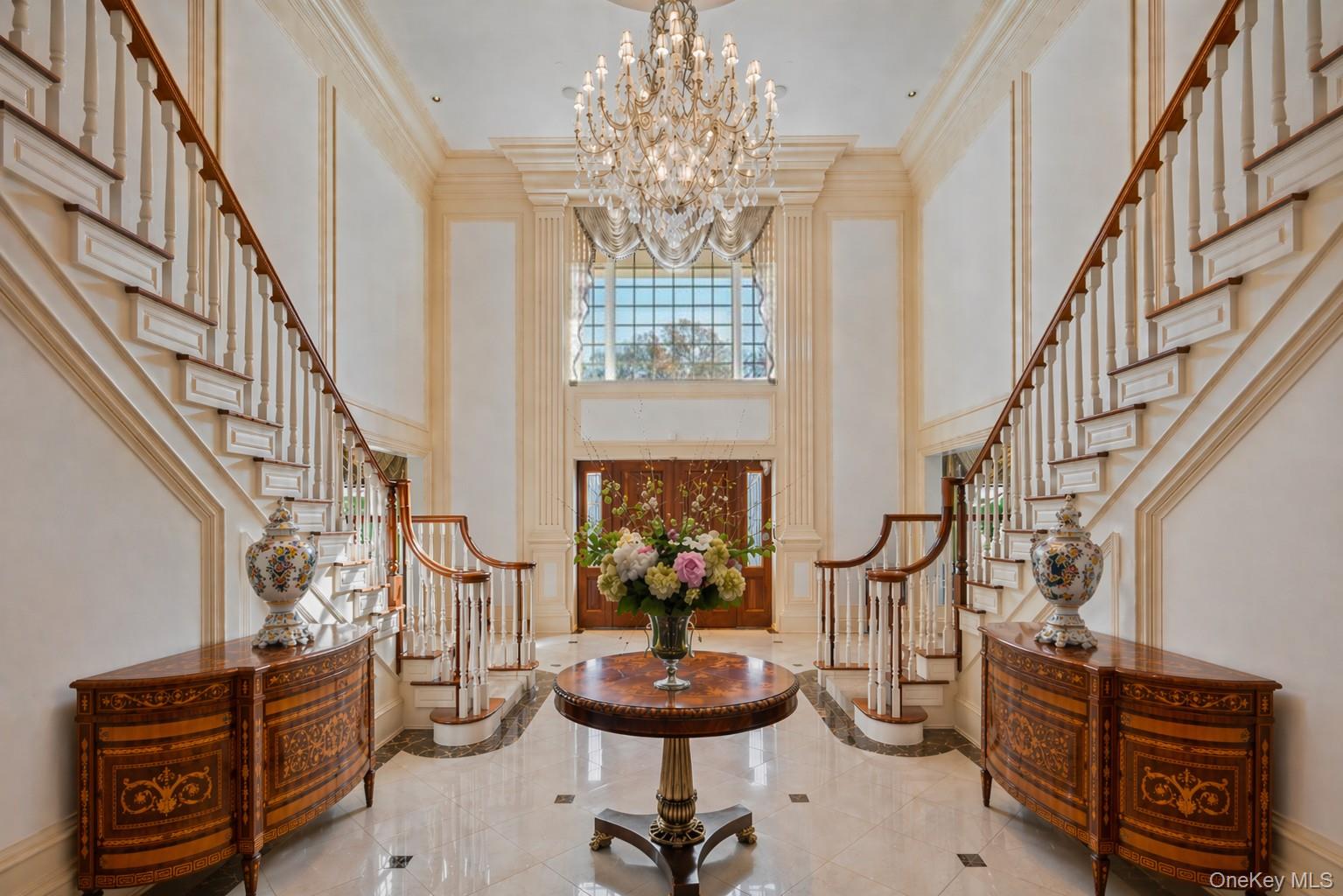 660 Chicken Valley Road Locust Valley, NY 11560 - Photo 4 of 48 Grand foyer featuring twin curved staircases with wood handrails and white balusters