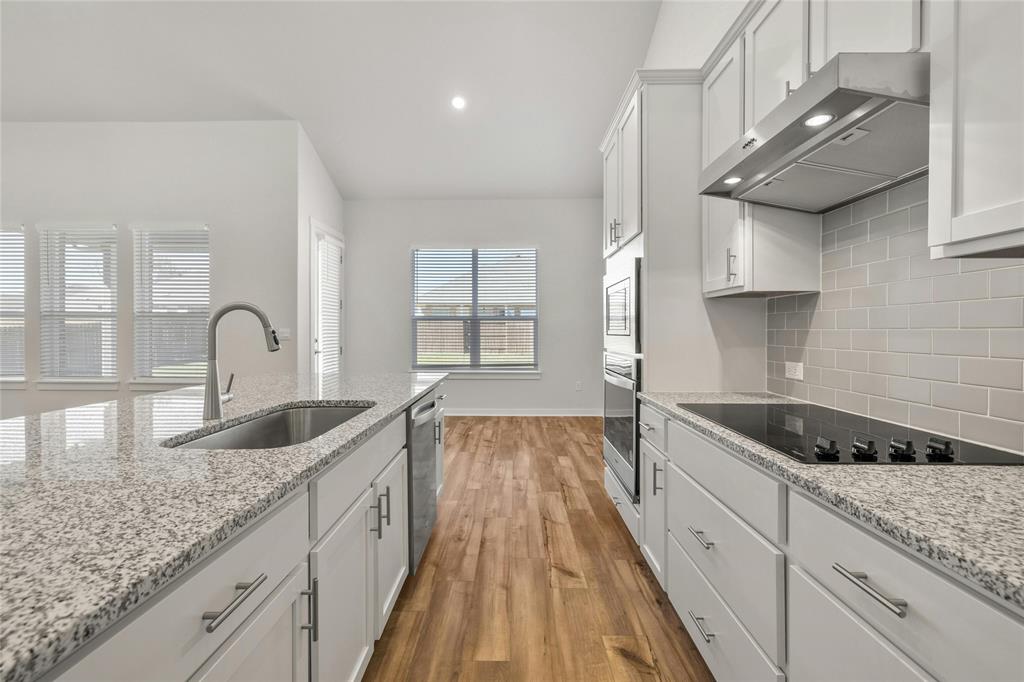 113 Shadow Oak Cove Georgetown, TX 78628 - Photo 12 of 40 A well-appointed kitchen features ample counter space, modern appliances, and rich wood flooring.