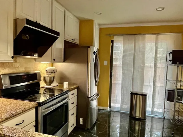 a view of an empty room with a fireplace and a window