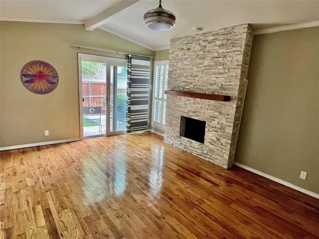 a view of a livingroom with wooden floor and a fireplace