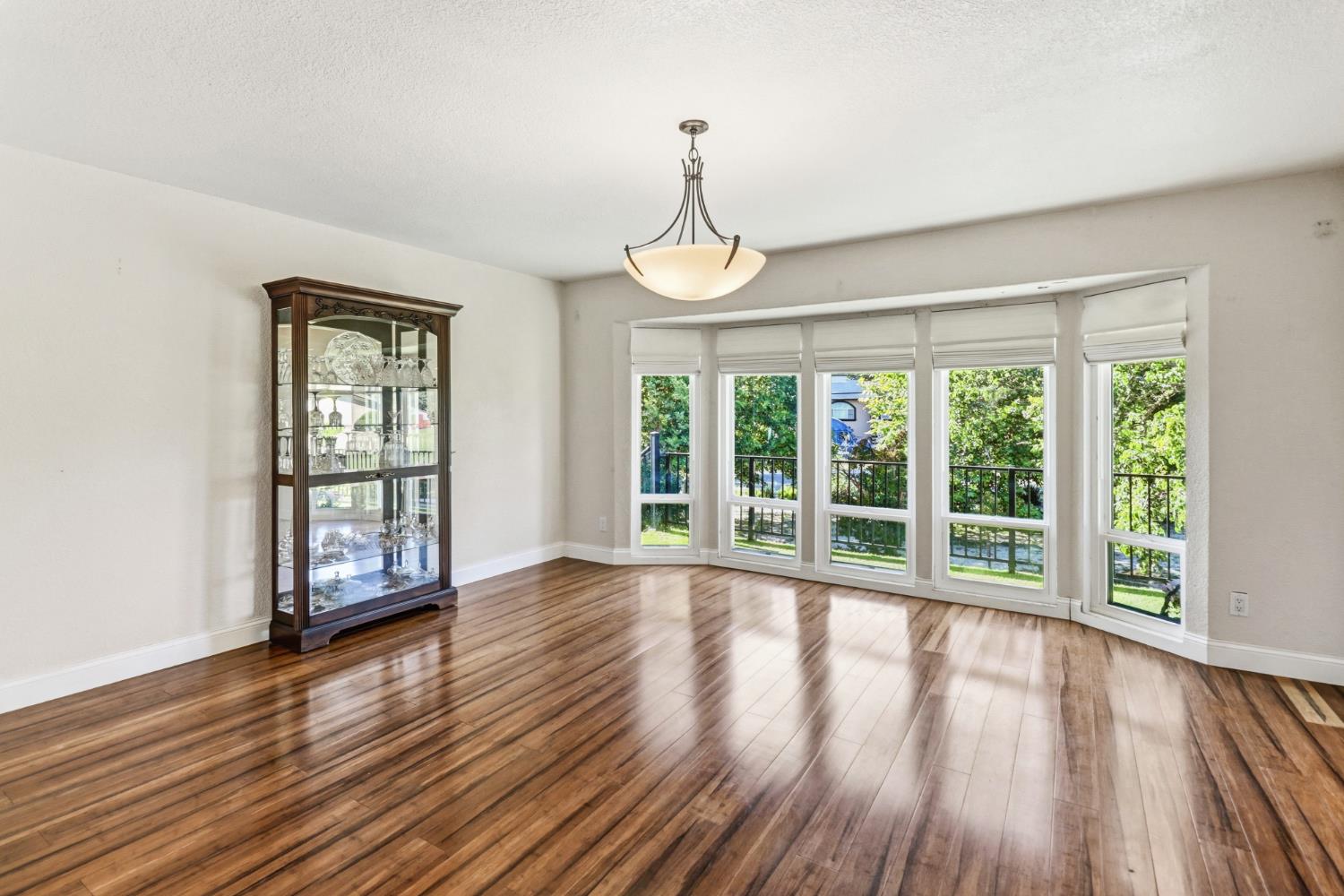 4330 Cavitt Stallman Road Granite Bay, CA 95746 - Photo 8 of 85 a view of an empty room with wooden floor and fan