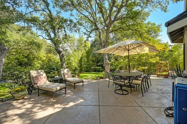 a view of patio with table and chairs under an umbrella