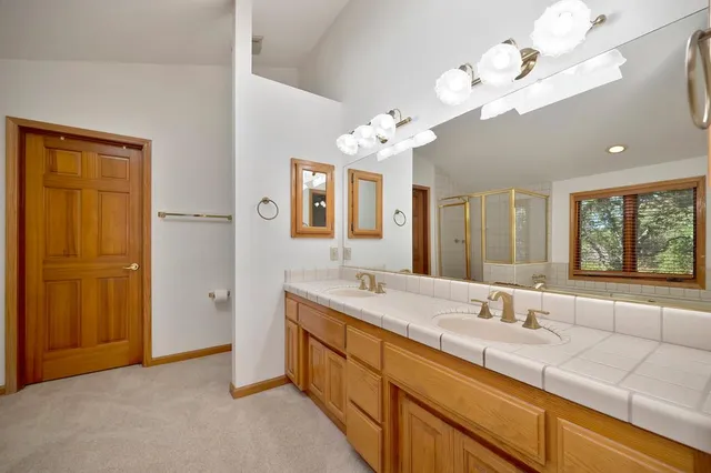 a spacious en suite bathroom with a double vanity sink and a mirror