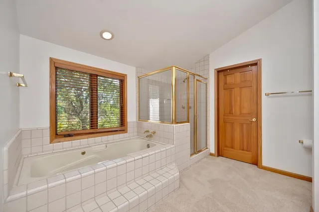 a spacious bathroom with a tub shower and sink
