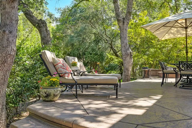 a view of patio with a table and chairs and potted plants