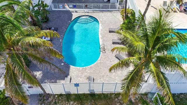 a view of swimming pool with a yard chairs and potted plants