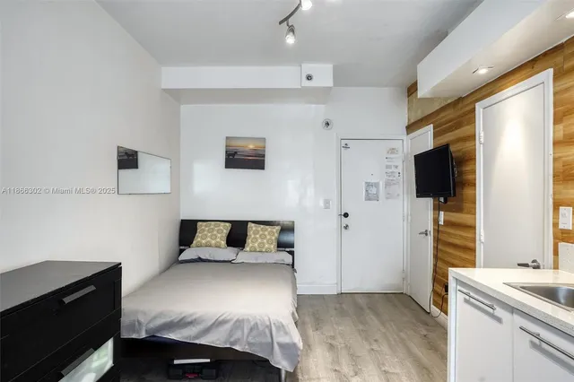 a bedroom with a bed and flat screen tv
