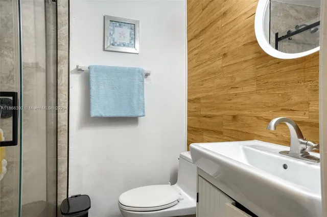 a bathroom with a toilet a sink and mirror