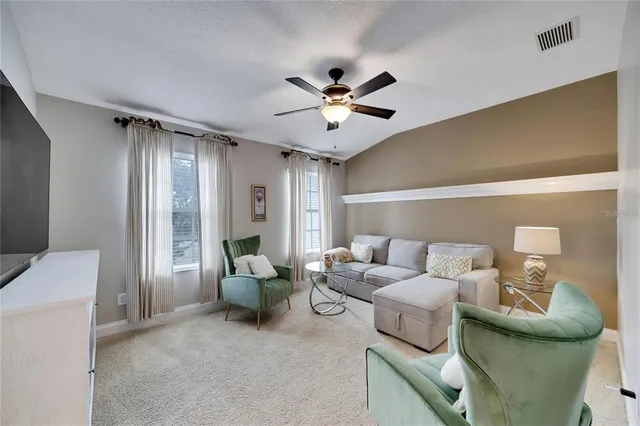 a living room with furniture and a ceiling fan