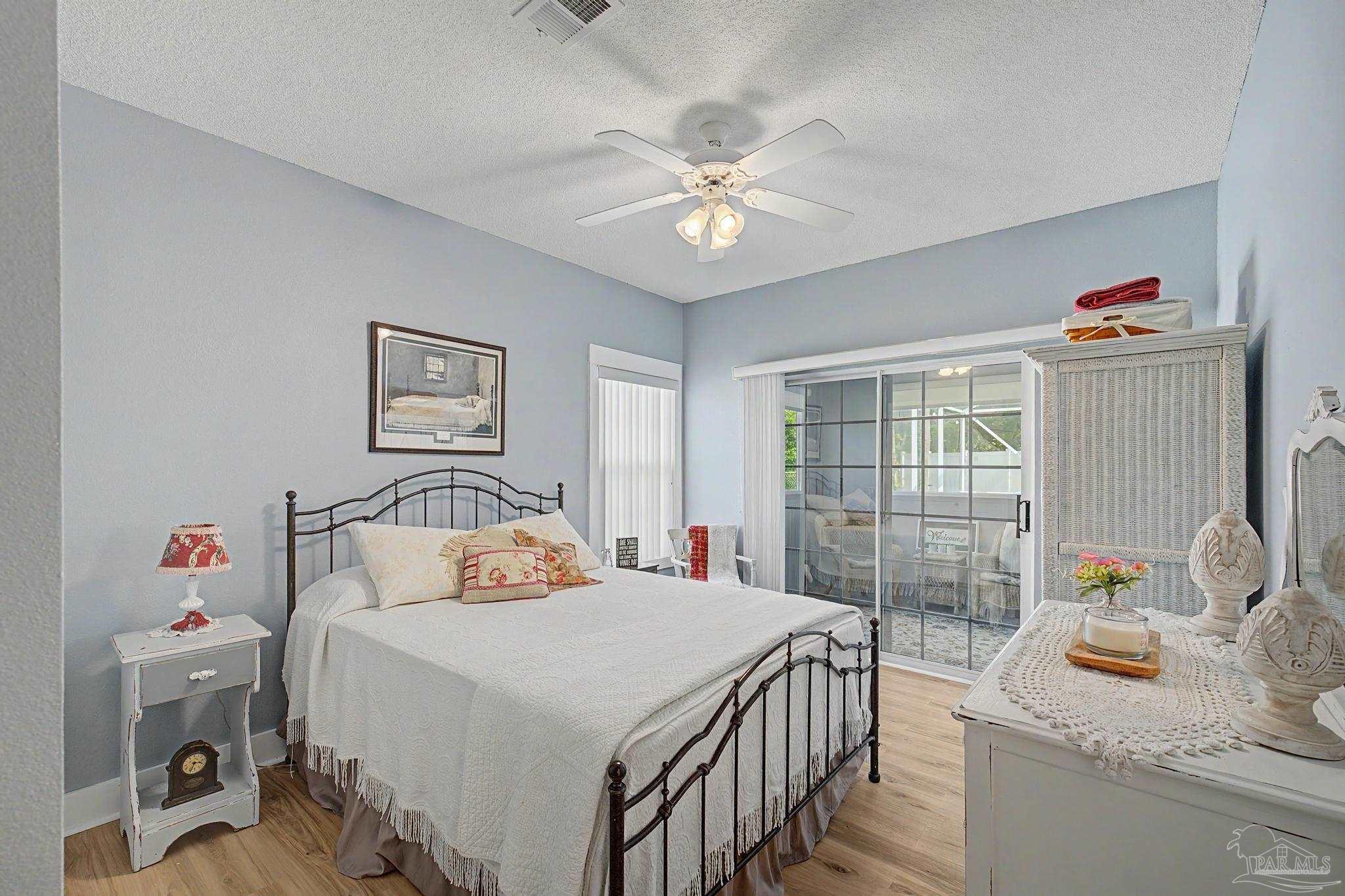 2005 Riviera Lane South Navarre, FL 32566 - Photo 32 of 70 a bedroom with a bed and a chandelier