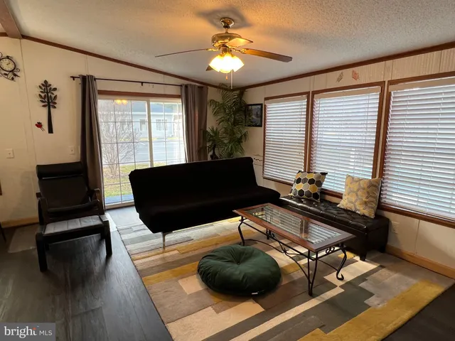 a kitchen with stainless steel appliances granite countertop a dining table chairs refrigerator and cabinets