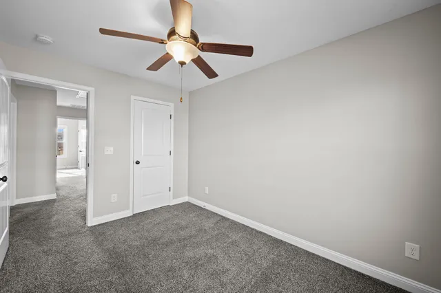 en empty room with ceiling fan and window