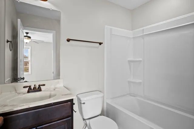 a bathroom with a sink toilet vanity and tub
