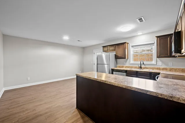 a kitchen with granite countertop a sink and a refrigerator