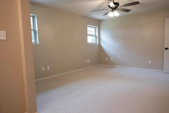 en empty room with windows and fan