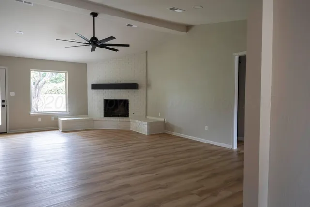 wooden floor fireplace and windows in an empty room