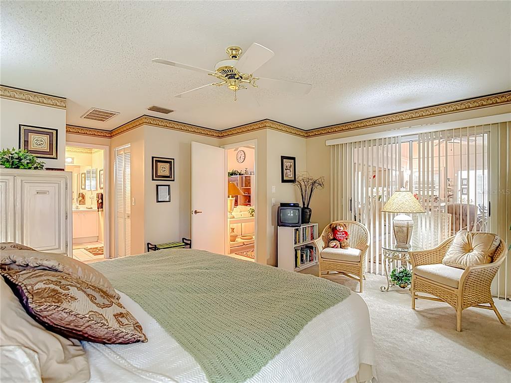 2337 Hidden Trail Drive Spring Hill, FL 34606 - Photo 13 of 24 a bedroom with a bed large window and a chandelier