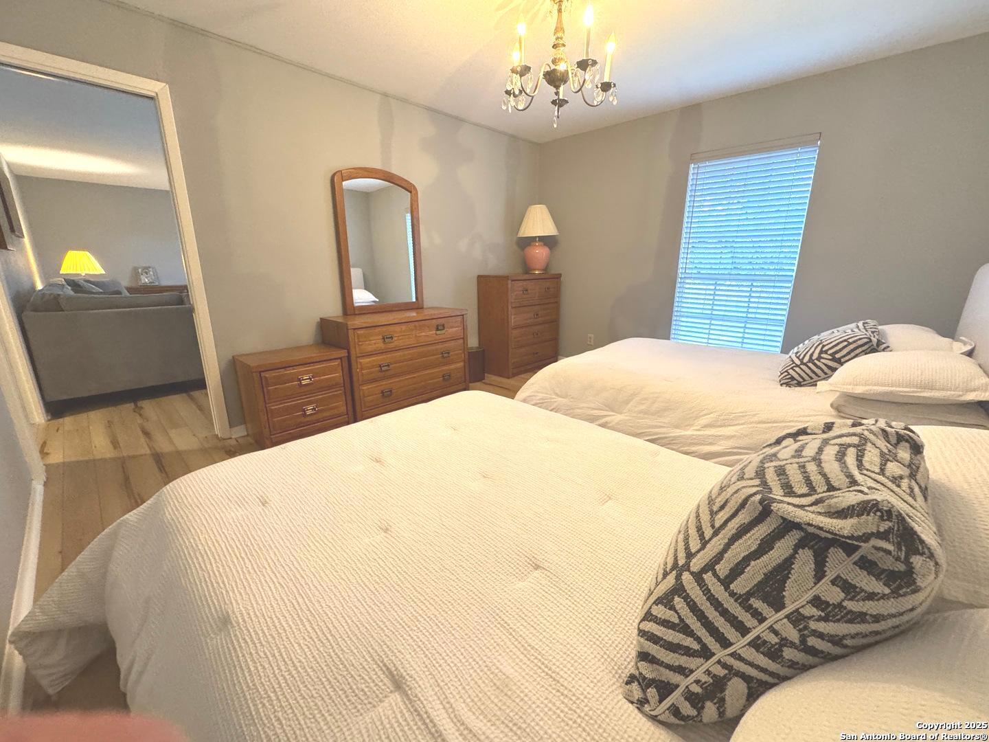 7500 Callaghan, Unit 254 San Antonio, TX 78229 - Photo 13 of 36 a bedroom with a bed and dresser with mirror