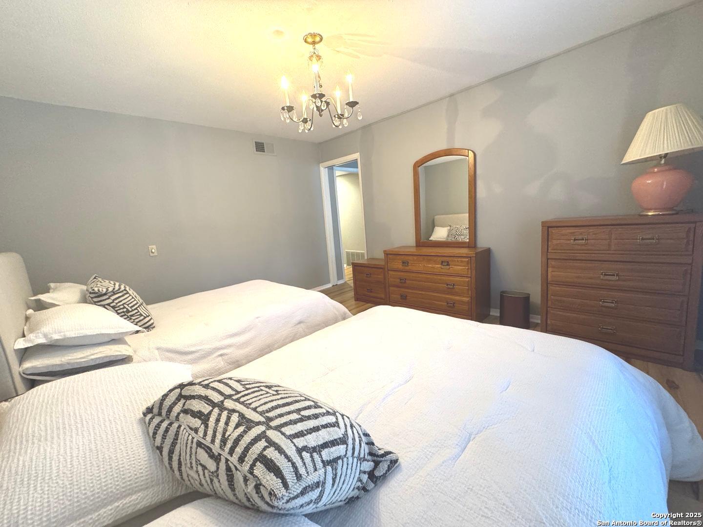 7500 Callaghan, Unit 254 San Antonio, TX 78229 - Photo 14 of 36 a bedroom with a bed and dresser with mirror