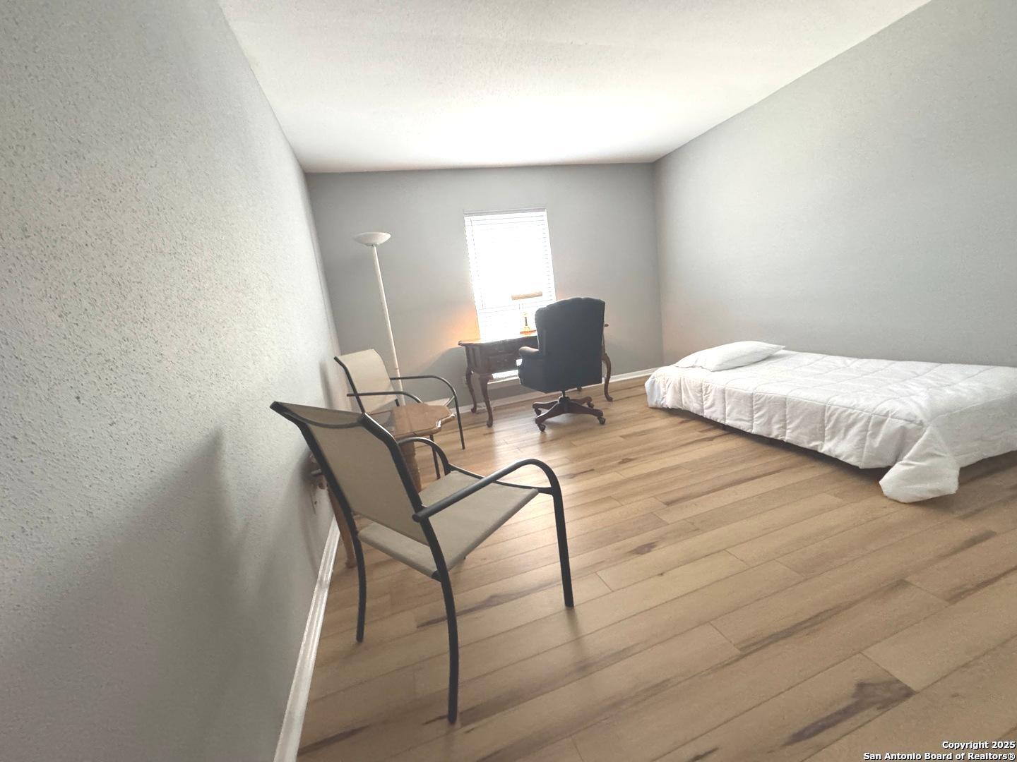 7500 Callaghan, Unit 254 San Antonio, TX 78229 - Photo 25 of 36 a bedroom with a bed and chair