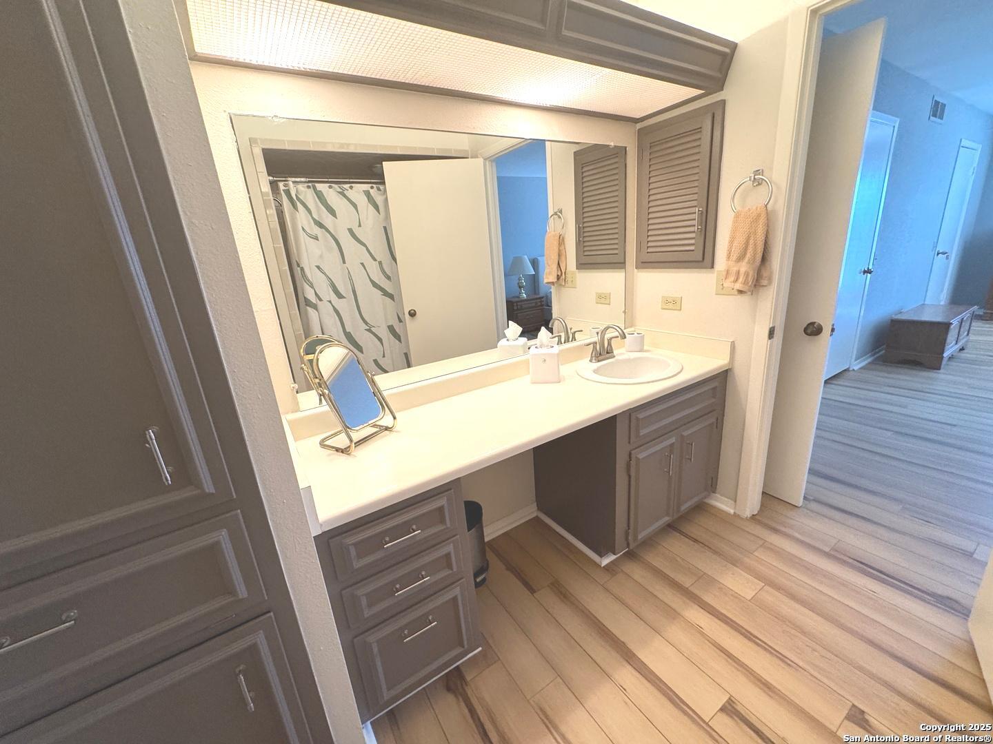 7500 Callaghan, Unit 254 San Antonio, TX 78229 - Photo 31 of 36 a bathroom with a sink a mirror and a shower