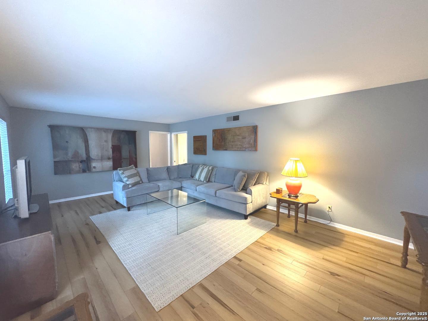 7500 Callaghan, Unit 254 San Antonio, TX 78229 - Photo 7 of 36 a living room with furniture and a wooden floor
