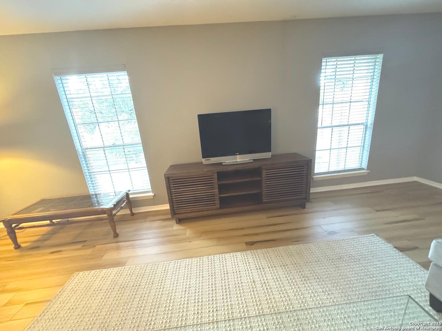 7500 Callaghan, Unit 254 San Antonio, TX 78229 - Photo 9 of 36 a view of an empty room with wooden floor and a window