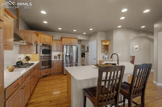 a spacious bathroom with a granite countertop sink a toilet a mirror a vanity and shower