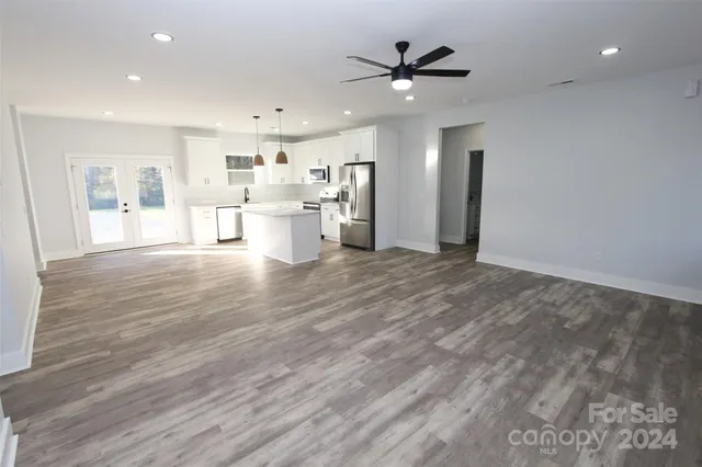 a view of a livingroom with furniture wooden floor and a ceiling fan