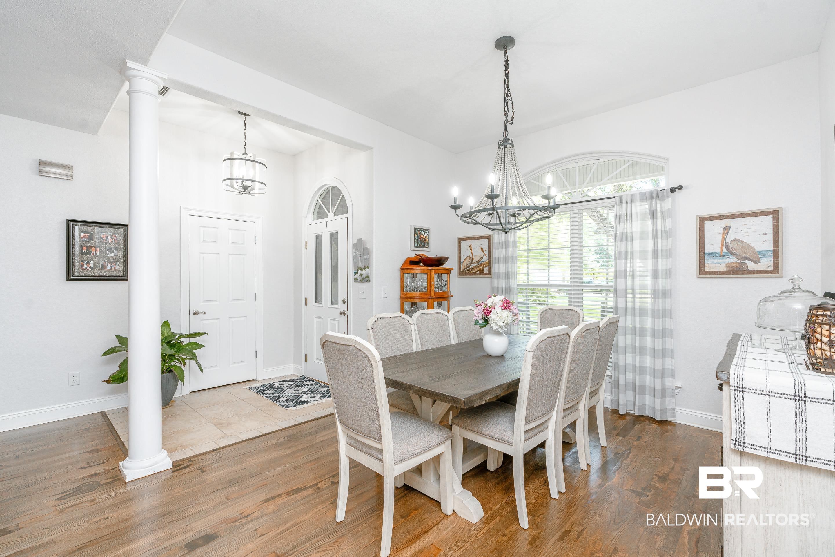 302 Bristol Way Foley, AL 36535 - Photo 9 of 51 Dining area featuring hardwood / wood-style flooring, a notable chandelier, and ornate columns