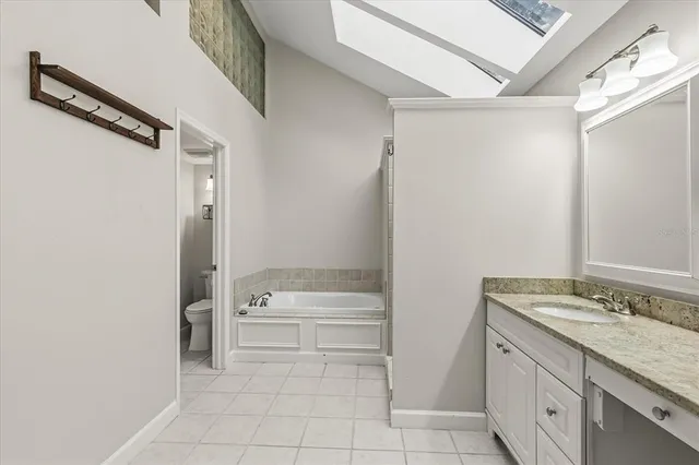 a bathroom with a granite countertop sink mirror and a bathtub