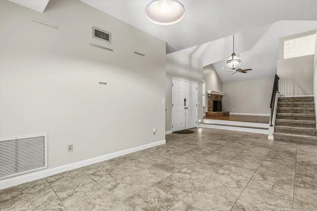 a view of a livingroom with wooden floor and staircase