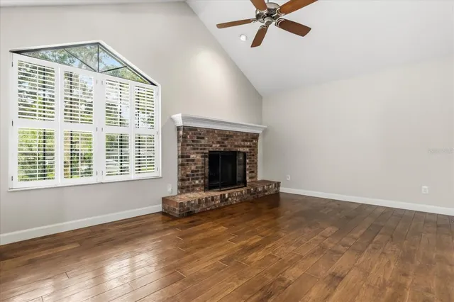 a view of an empty room with a fireplace and a window