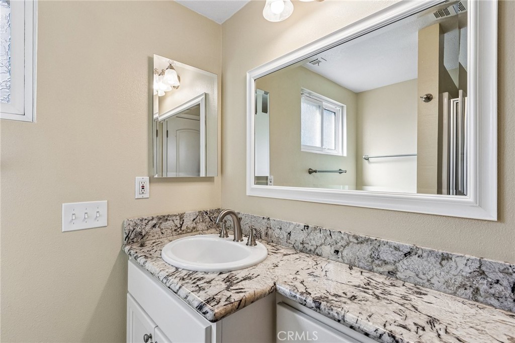 486 South Rall Avenue La Puente, CA 91746 - Photo 35 of 42 a bathroom with a granite countertop sink and a mirror