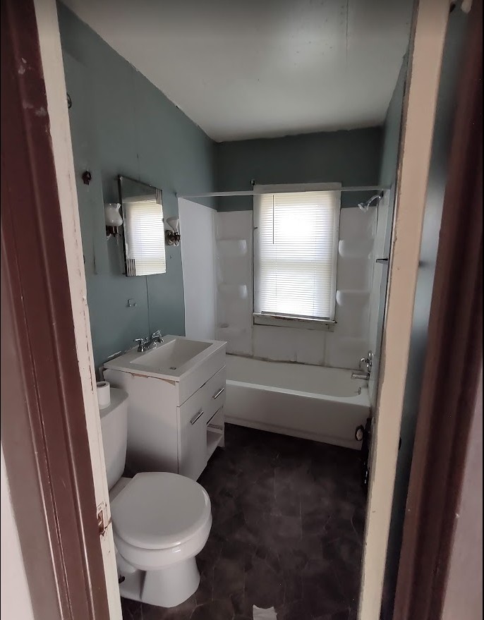 329 Albert Boulevard Kankakee, IL 60901 - Photo 11 of 12 a bathroom with a granite countertop toilet a sink and a bathtub