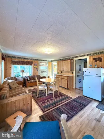 a living room with furniture stove and wooden floor