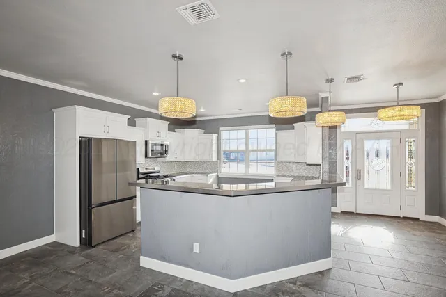 a kitchen with stainless steel appliances granite countertop a sink a stove and a refrigerator