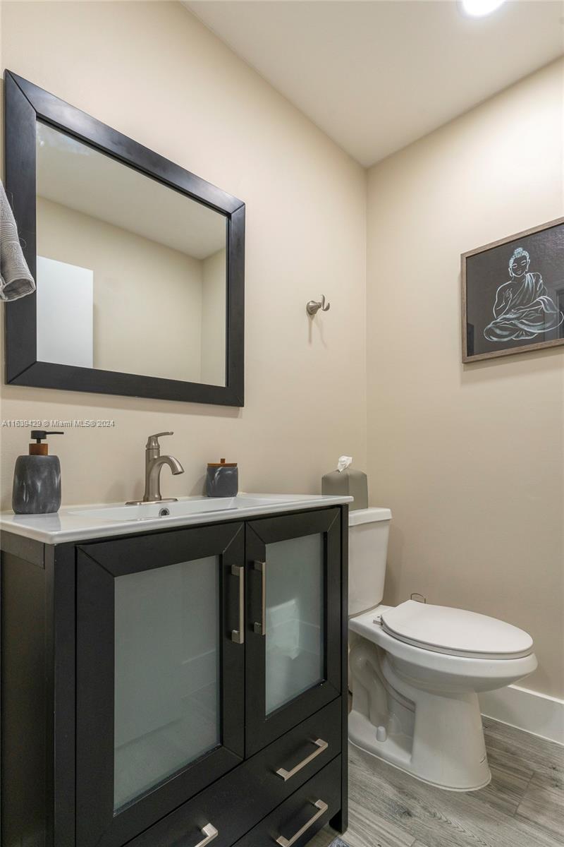 18606 Southwest 100th Avenue, Unit 18606 Cutler Bay, FL 33157 - Photo 12 of 29 a bathroom with a toilet sink vanity and mirror