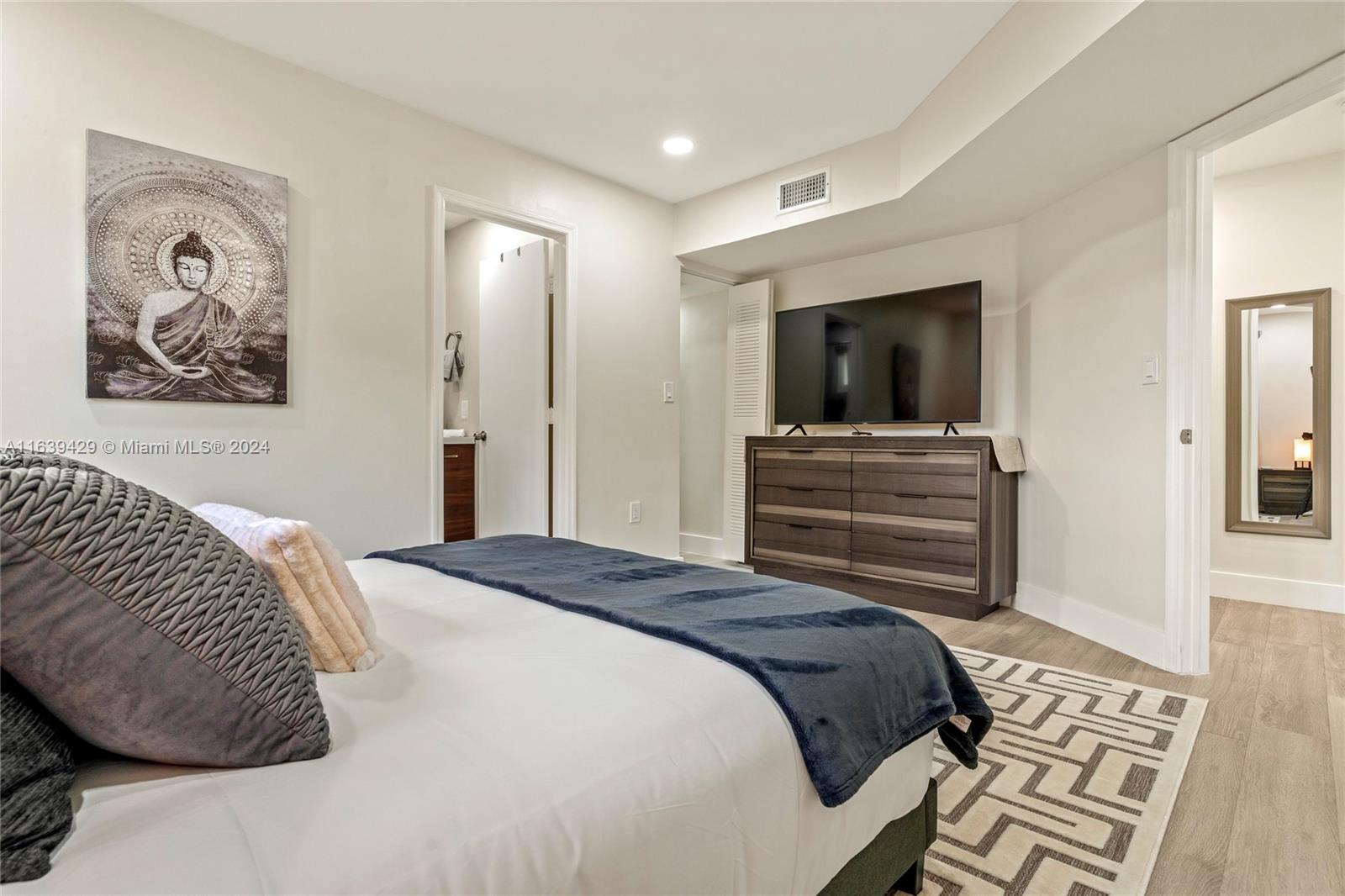 18606 Southwest 100th Avenue, Unit 18606 Cutler Bay, FL 33157 - Photo 19 of 29 a bedroom with a bed and a television