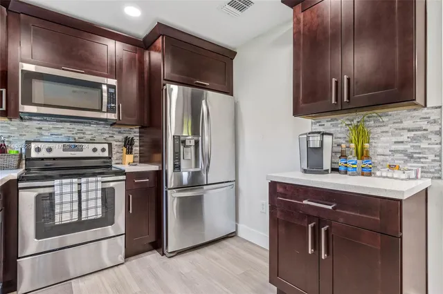 a kitchen with stainless steel appliances granite countertop a refrigerator stove and sink