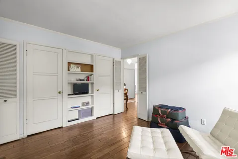 a view of a bedroom with furniture and wooden floor