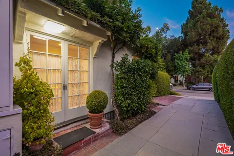 a potted plant sitting in front of a house with a garden