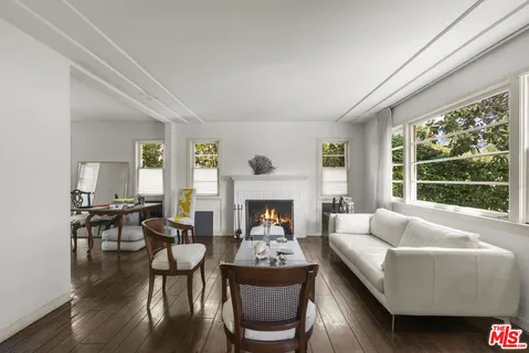a living room with furniture fireplace and a large window