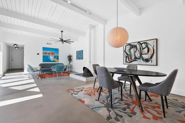 a living room with furniture and paintings on the wall