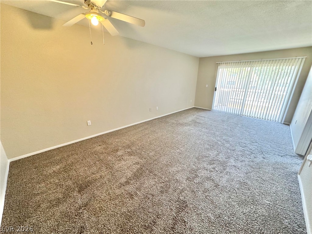 8070 West Russell Road, Unit 2121 Las Vegas, NV 89113 - Photo 2 of 22 A spacious room offers comfortable carpeting and convenient sliding door access to outdoor space.