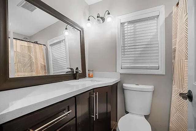 a bathroom with a sink a toilet and a mirror