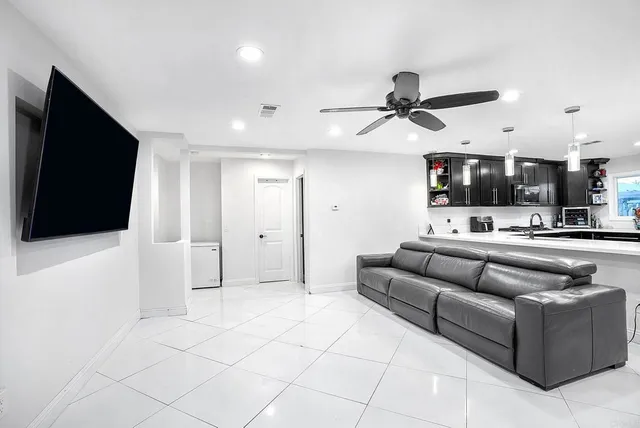 a kitchen with stainless steel appliances kitchen island granite countertop a refrigerator a stove a sink a dining table and chairs