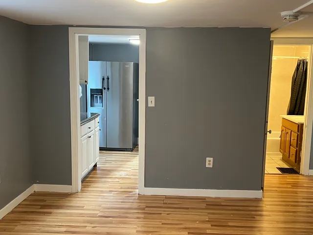 a view of a livingroom with wooden floor and a flat screen tv